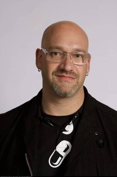 Bald man wearing glasses and a black shirt
