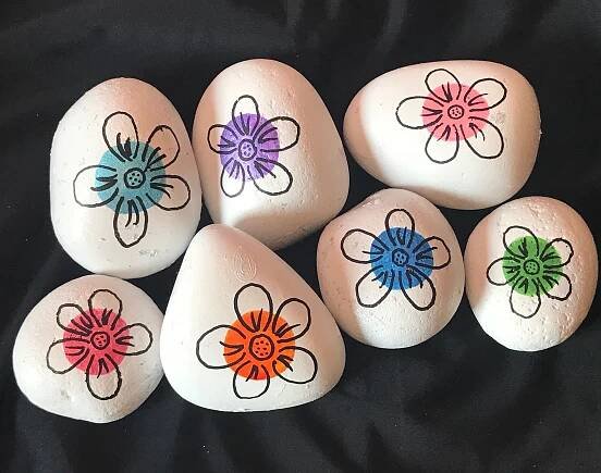 six painted rocks with flowers on them