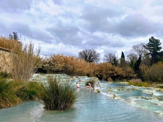People soak in the Cascate del Mulino hot springs in Saturnia, Tuscany, Italy.