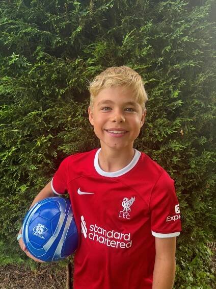 Photo of Jasper Day, a boy with Duchenne muscular dystrophy, holding a soccer ball.
