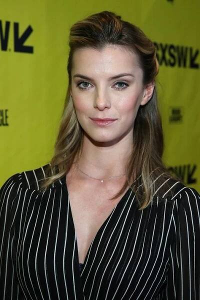 a woman with long hair wearing a black and white striped shirt is posing for the camera