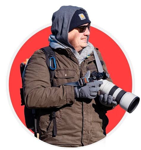 Cesar Garcia standing with a camera in hand, waiting for the right moment to capture a photograph