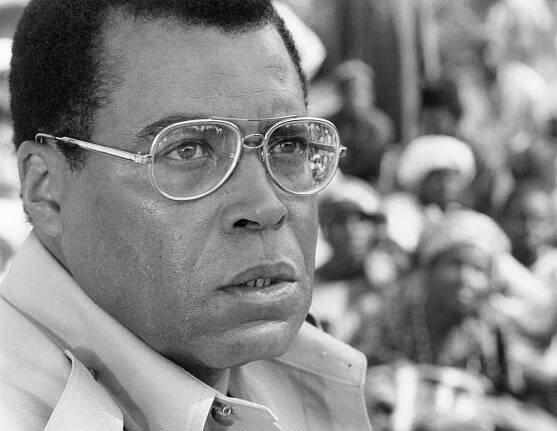 A black and white portrait of Mr. Jones wearing glasses and looking away from the camera with a serious expression on his face.