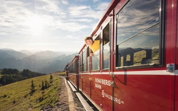 Mann in einem gelben T-Shirt schau aus dem Fenster der SchafbergBahn 