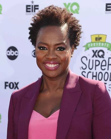 Viola Davis wears a curly pixie cut, a pink shirt, and a burgundy blazer
