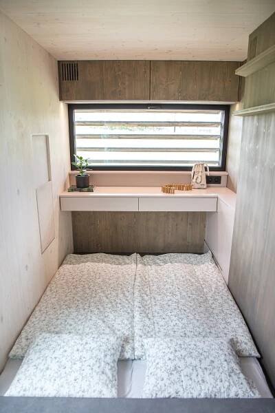 a small room with a bed in front of a window at Ubytování na Poli designu in Bílovice
