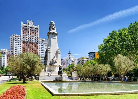 Stáhnout - Pohled na památník Cervantes a Španělsko Building (Edificio Espana) na náměstí Španělska (Plaza de Espana) na modrém nebeském pozadí v Madridu. Madrid je oblíbeným turistickým cílem Evropy. — Stock obrázek