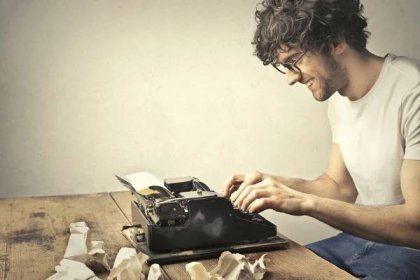 Smiling writer types on a typewriter