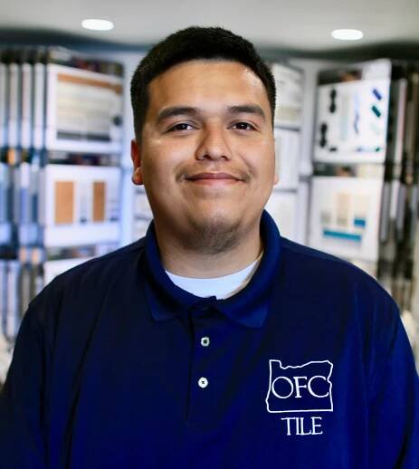 Smiling man in tile showroom wearing OFC Tile shirt.