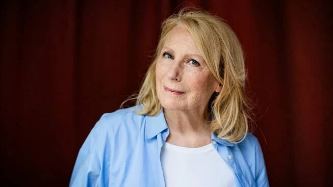 Die Schauspielerin und Kabarettistin Maren Kroymann steht vor einem roten Vorhang und schaut in die Kamera. (Foto: picture-alliance / Reportdienste, picture alliance/dpa | Christoph Soeder)