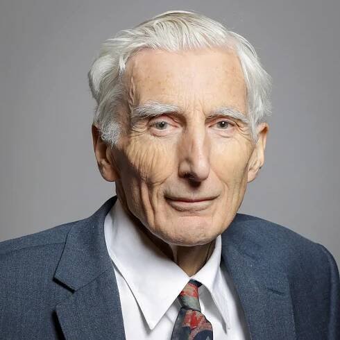 Elderly man in formal attire with white hair and a tie, posing for a portrait against a neutral background.
