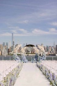 A wedding aisle with blue and white ombre floral decorations.