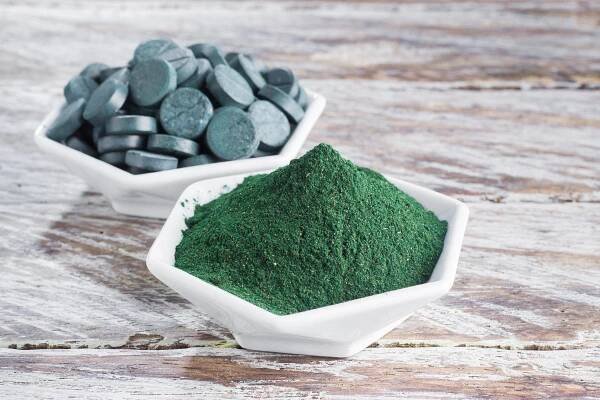 Spirulina je dostupná v prášku,  který můžeme přidávat do smoothie a šťáv,  nebo je jednoduše slisovaná do malých tabletek | foto: Fotobanka Profimedia