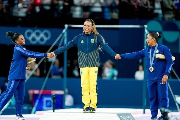 Simone Biles of United States and bronze medalist Jordan Chiles of the United States celebrate gold medalist Rebeca Andrade of Brazil during the medal ceremony after the Women's Floor Exercise Final on day ten of the Olympic Games Paris 2024