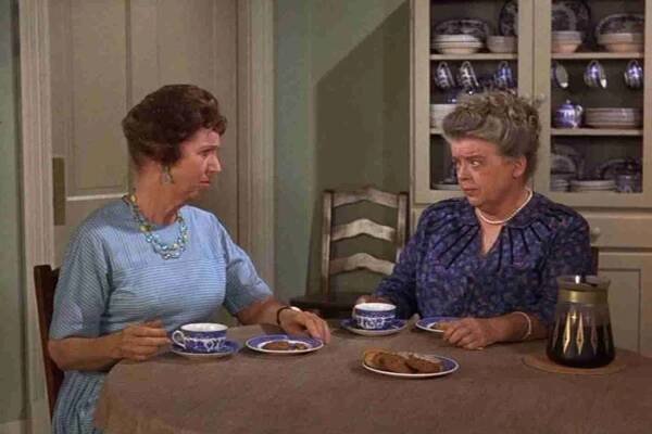 A couple of women sitting at a table eating food Description automatically generated with low confidence