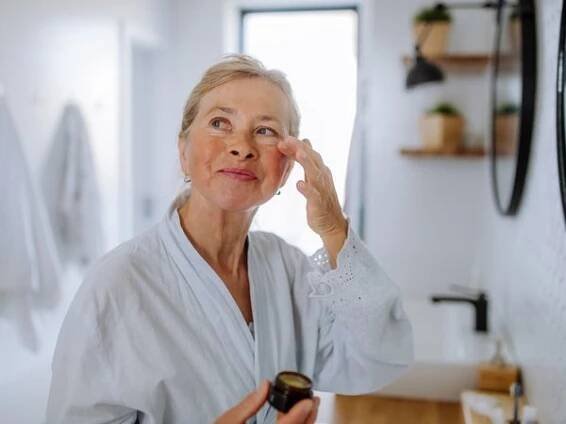 person putting cream under eyes