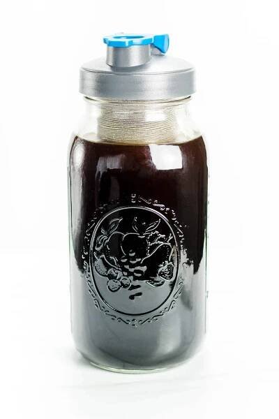 A mason jar with lid contains rich, dark cold brew coffee.