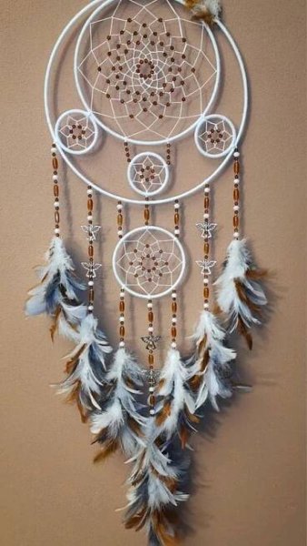 a white dream catcher hanging on the wall
