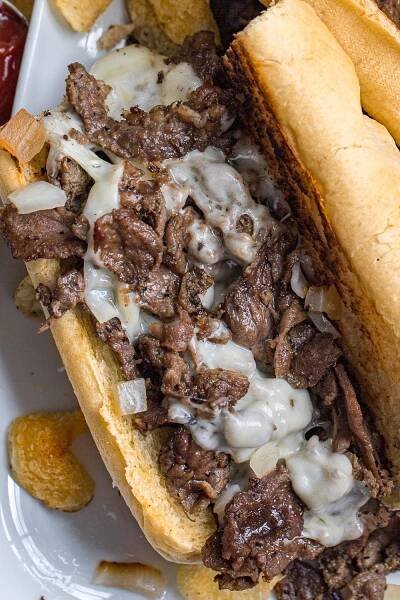 The only ingredients in an Authentic Philly cheesesteak are thinly sliced steak, fried onions, and cheese! This Philly cheesesteak recipe is true to the original Cheesesteak sandwich and is made with tender shavings of beef, sauteed onions, and cheese all tucked inside toasted long bread! 