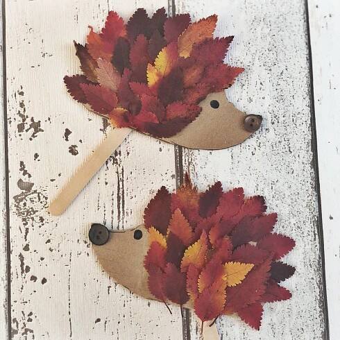 two hedges made out of leaves sitting on top of a white wooden table next to each other