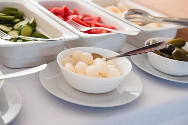a white bowl of food on a table with bowls of food at HOTEL AGRI in Soběšice