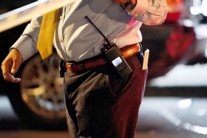 A general view of the handcuffs, gun holster, walkie talkie and badge on the belt of an NYPD detective at the scene where a five year old was reportedly shot on White Plains Road at E213rd Street in the Bronx, NY