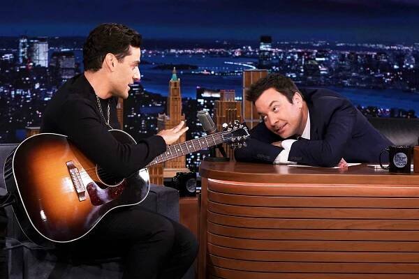 Oscar Isaac plays guitar during an interview with host Jimmy Fallon on Friday, October 15, 2021.