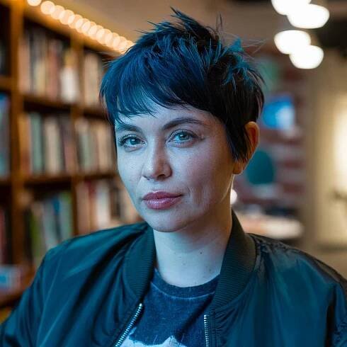 Deep blue short spiky pixie with choppy bangs, styled for texture and definition in a modern, edgy finish