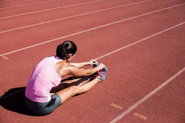 Female athlete stretching her hamstring
