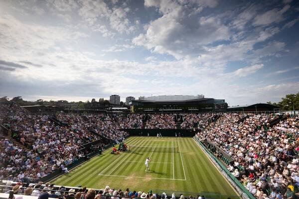 a tennis match is being played in front of a large crowd