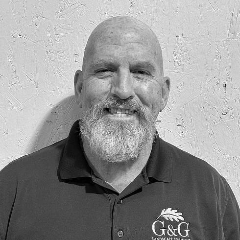 A black and white photo of a bald man with a beard.