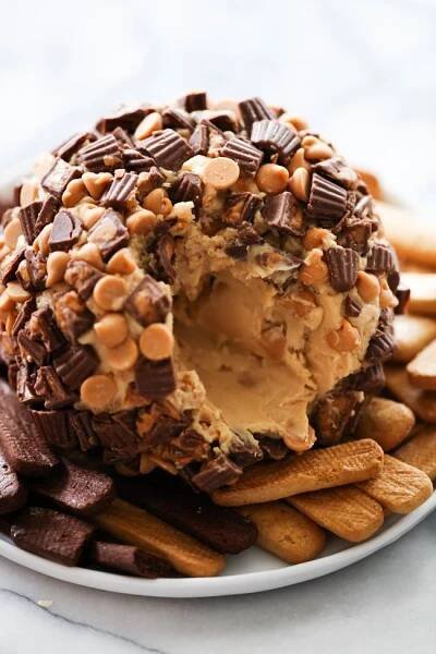 a chocolate covered donut surrounded by cookies and crackers on a white platter