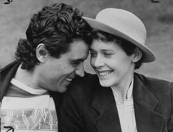 a black and white photo of a man and woman looking at each other