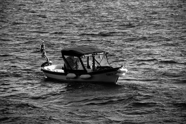 A small boat floating on top of a large body of water