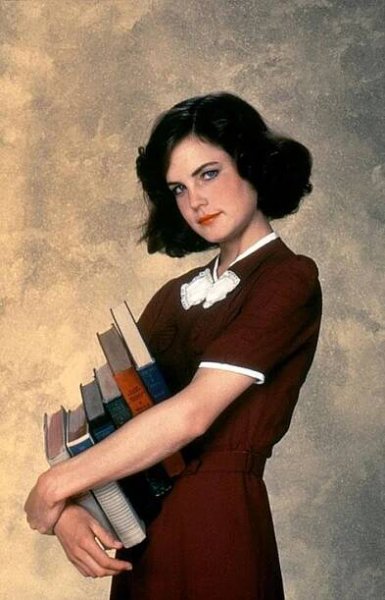 a woman holding a stack of books in her hands
