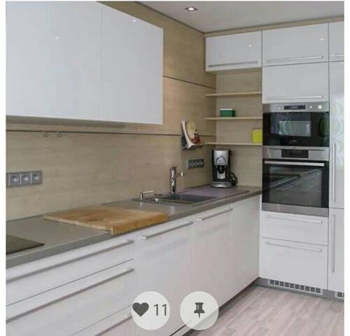 a modern kitchen with white cabinets and stainless steel counter tops is pictured in this image