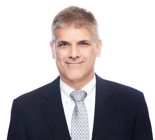 A man in a suit and tie is smiling for the camera.