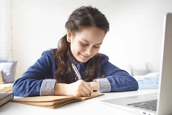 child writing on a paper