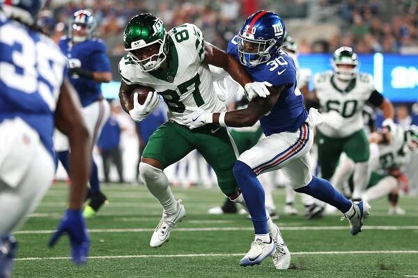 Brandon Smith #87 of the New York Jets carries the ball as TJ Moore #30 of the New York Giants defends during the first half of the NFL Preseason 2025 game between New York Jets and New York Giants at MetLife Stadium on August 16, 2025 in East Rutherford, New Jersey. 