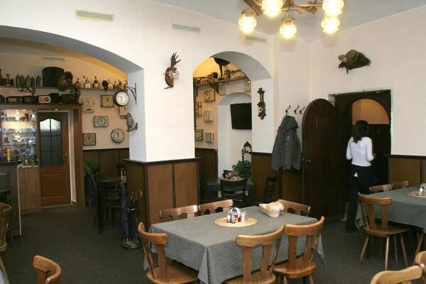a restaurant with a table and chairs in a room at Penzion Aladdin in Teplice