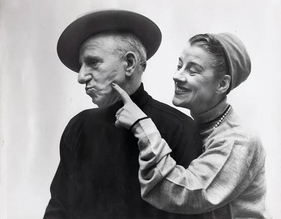 Richard Avedon, Jimmy Durante & Beatrice Lillie, ​1951. A woman stands to the right, smiling towards a man in black. She points to the lipstick mark on his left cheek. Both have heads turned to the left.
