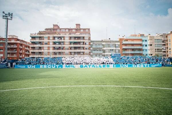 Los aficionados del CE Europa lucen un tifo en el Nou Sardenya.