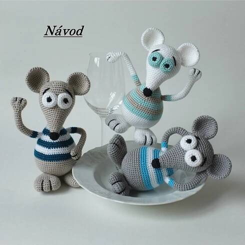 three crocheted mice on a plate with one holding a wine glass in the other hand