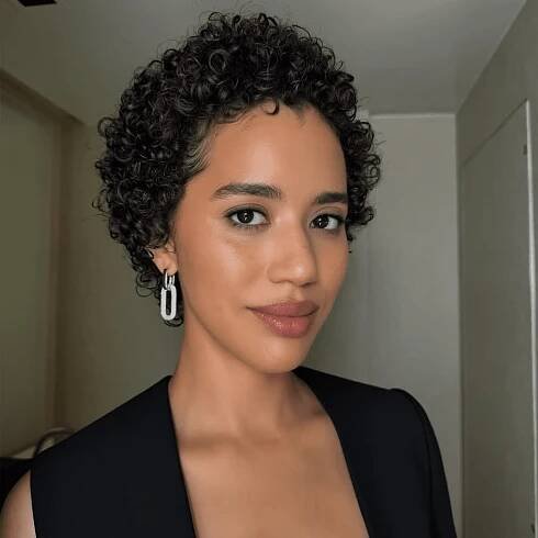 Jasmin Savoy Brown with short curly hair and earrings