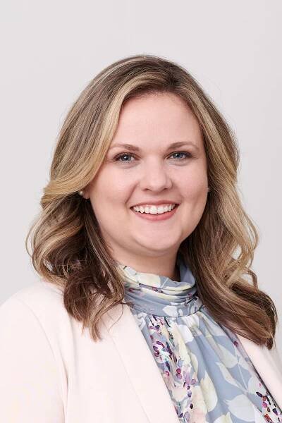 Miller Kaplan partner, Kelly Pollard, facing camera, smiling, on light grey background.