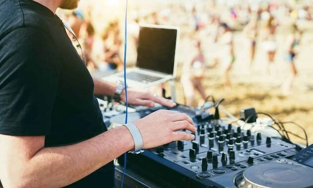 Dj mixing music at beach party during summer event
