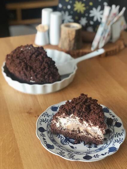 a piece of cake sitting on top of a blue and white plate next to a cupcake