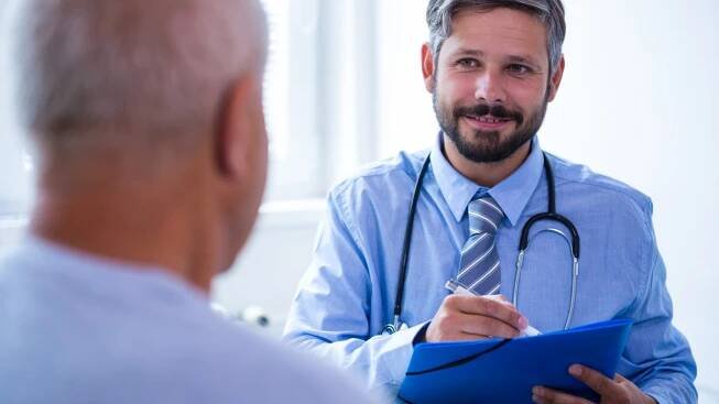 Image shows a patient consulting a doctor at a hospital.