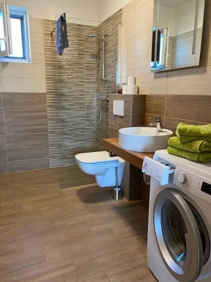 a bathroom with a washing machine and a washer at Apartmány Přítluky in Přítluky