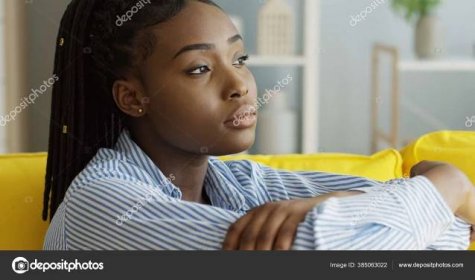 Stáhnout - Detailní záběr smutné deprimované Afroameričanky sedící na gauči a přemýšlející. Uvnitř — Stock obrázek